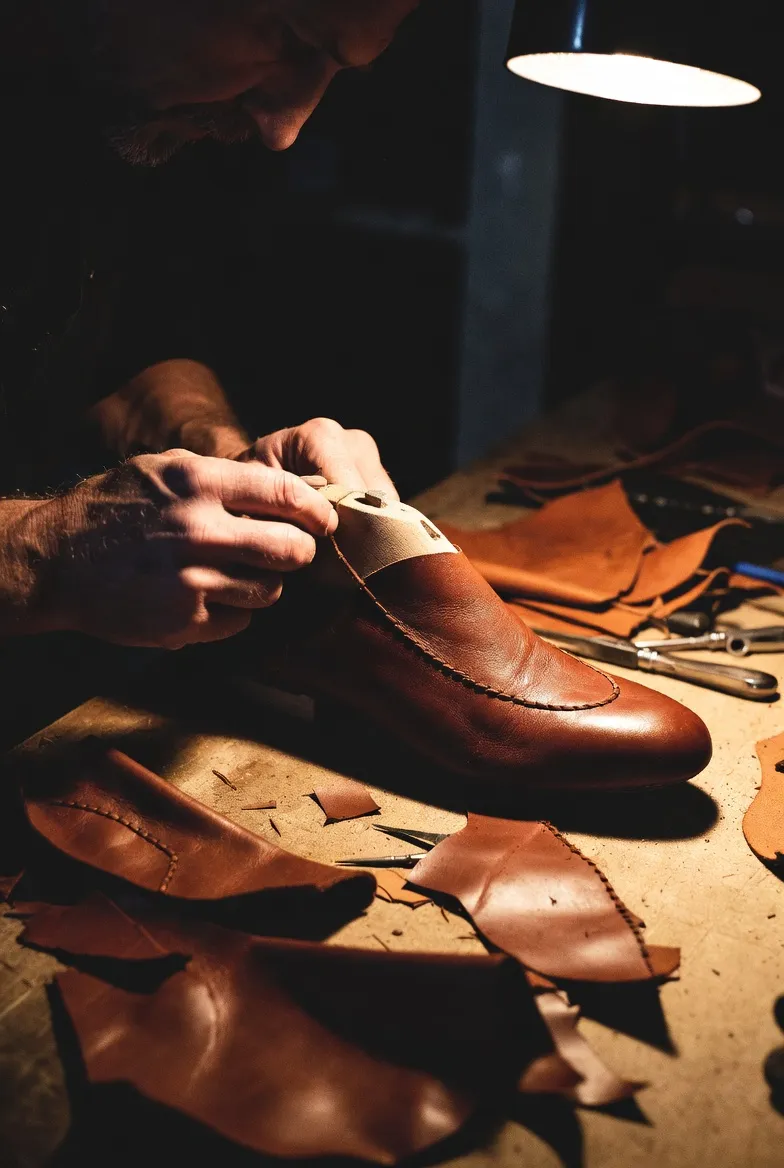 Shoe prototyping at Handmade Shoe Factory, artisan hand-stitching a leather shoe sample
