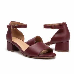 Private label wide fit low heel ankle strap sandal in a burgundy studio presentation, shown from a front three-quarter view for brands, wholesalers, retailers, importers and B2B footwear sourcing.